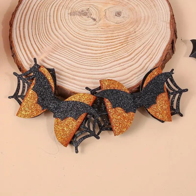 Halloween glitter bow with black bats and orange accents on wooden background