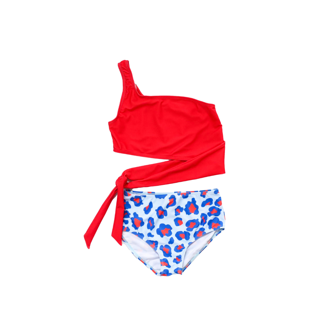 Seaglass Azure two-piece swimsuit with asymmetrical neckline and high-waisted bottoms featuring a coordinating sash tie.