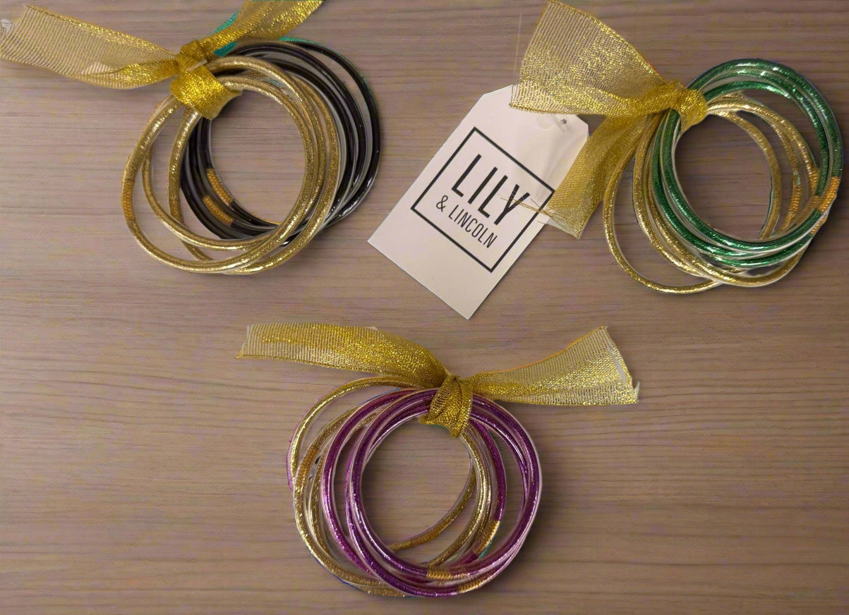 Set of Go Team plastic bracelets in green, purple, black, and gold colors with festive gold ribbons.