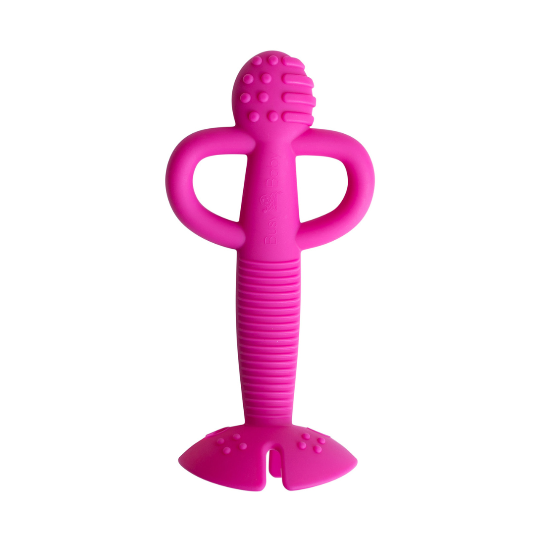 Pink 2-in-1 teether and training spoon made of food-grade silicone with textured head and gripped handle for babies.