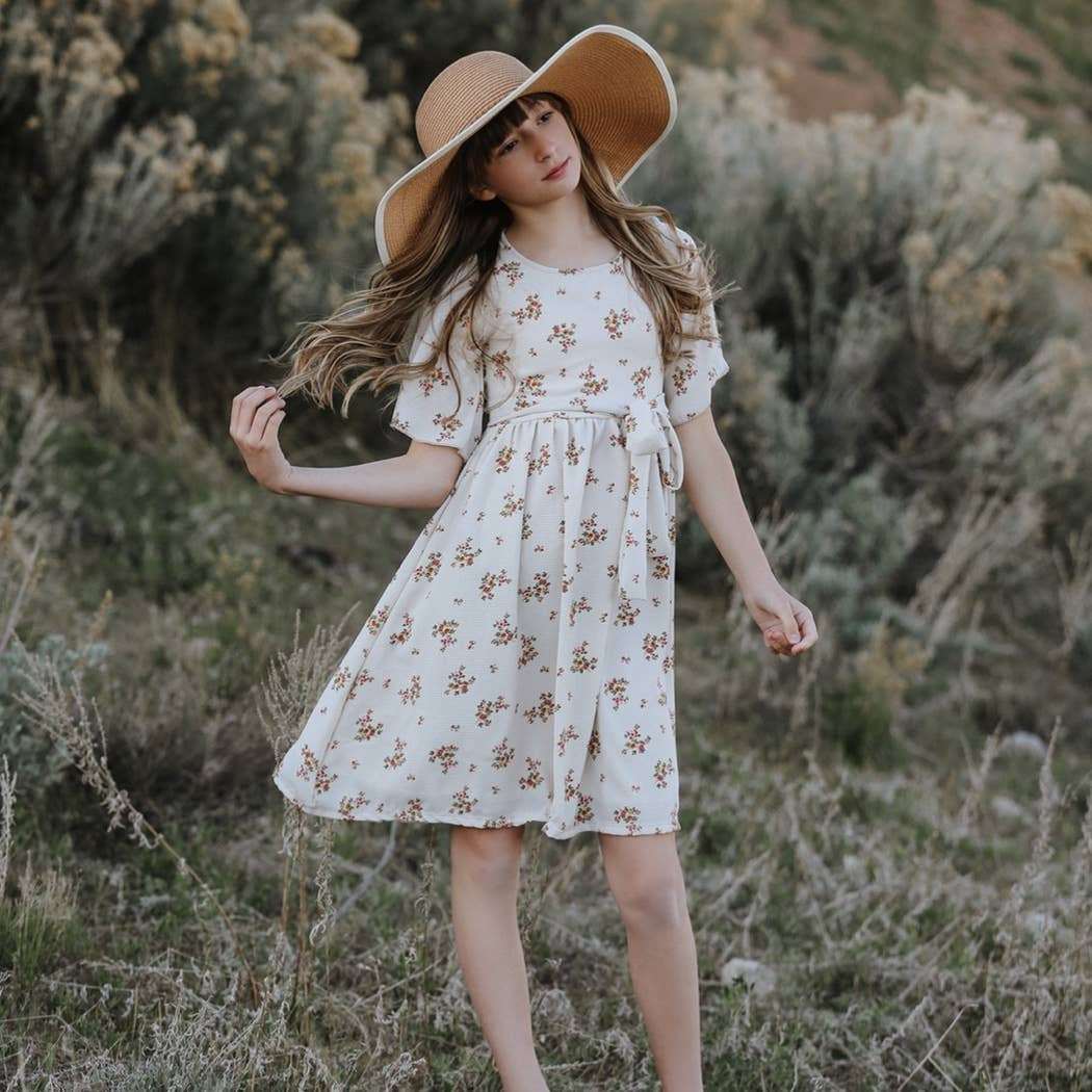 Etta Cream Floral Dress with pockets and tie waist in a natural setting.