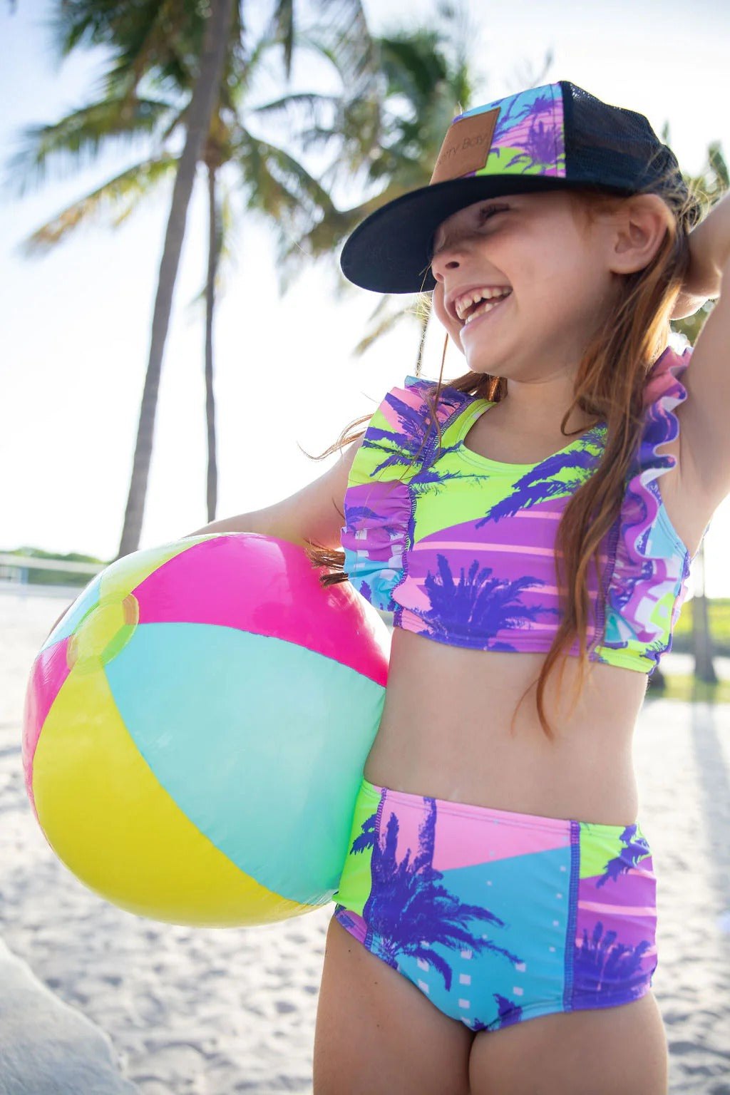 Girl wearing Blueberry Bay - Coral Gables Two Piece Swimsuit with beach ball.