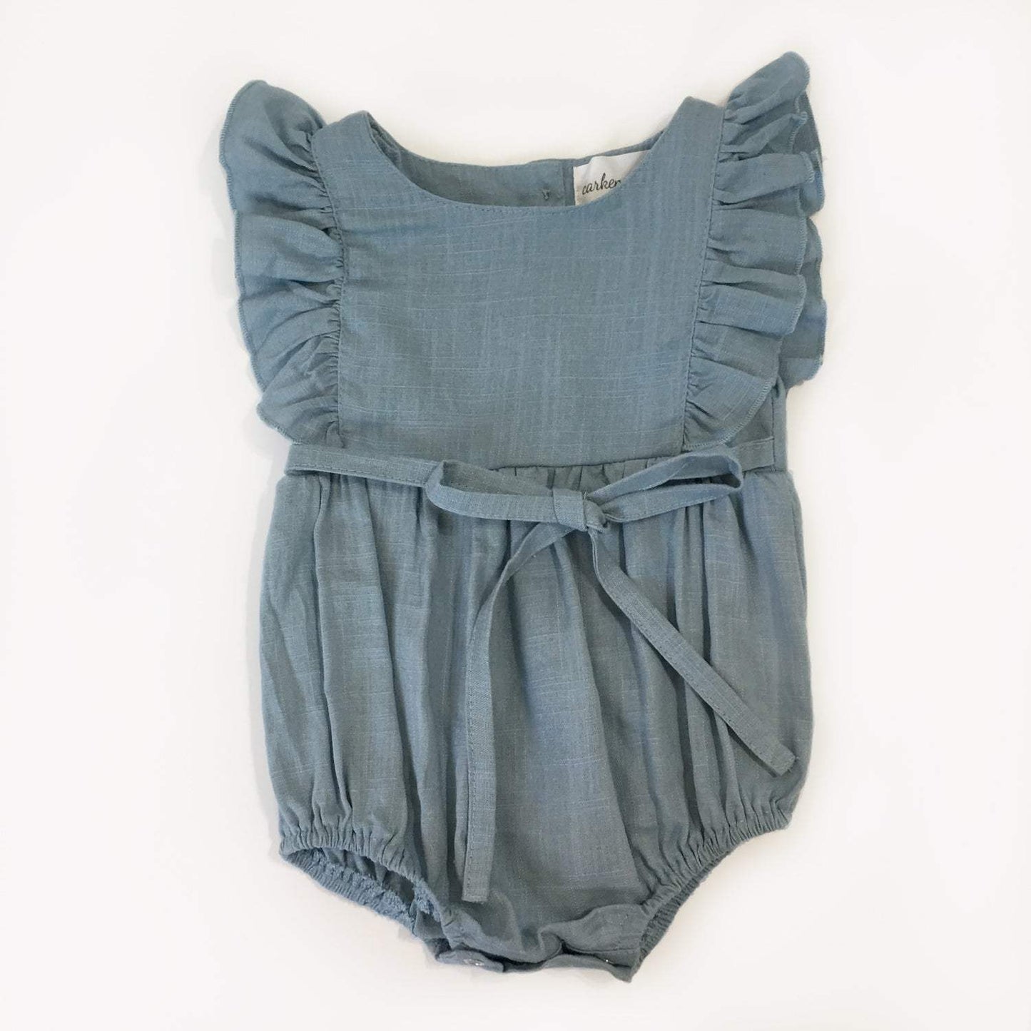 Medium blue linen ruffle romper with waist tie and elastic leg holes.