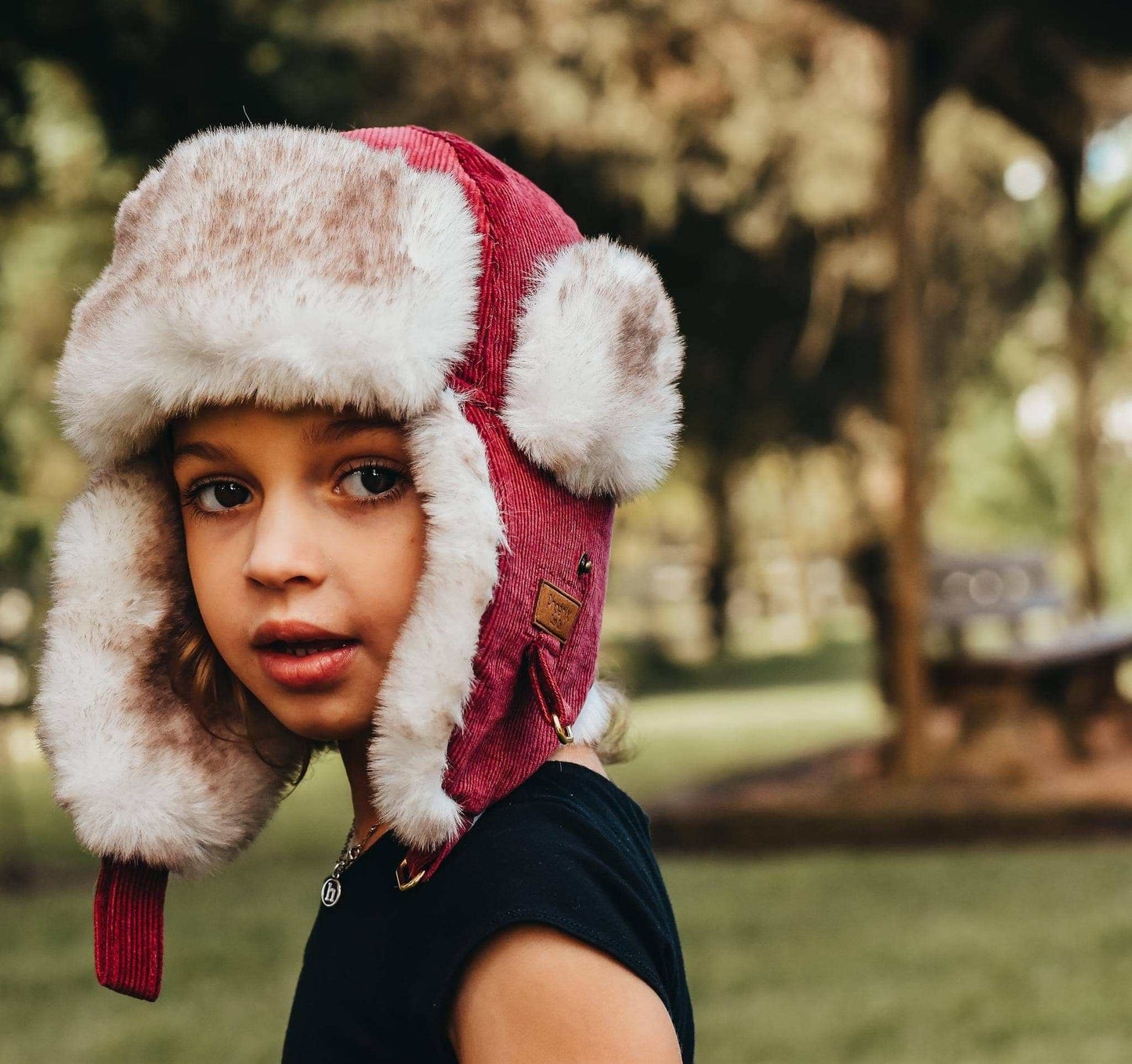 Child wearing Winterberry Trapper Hat with faux fur lining and ear flaps.