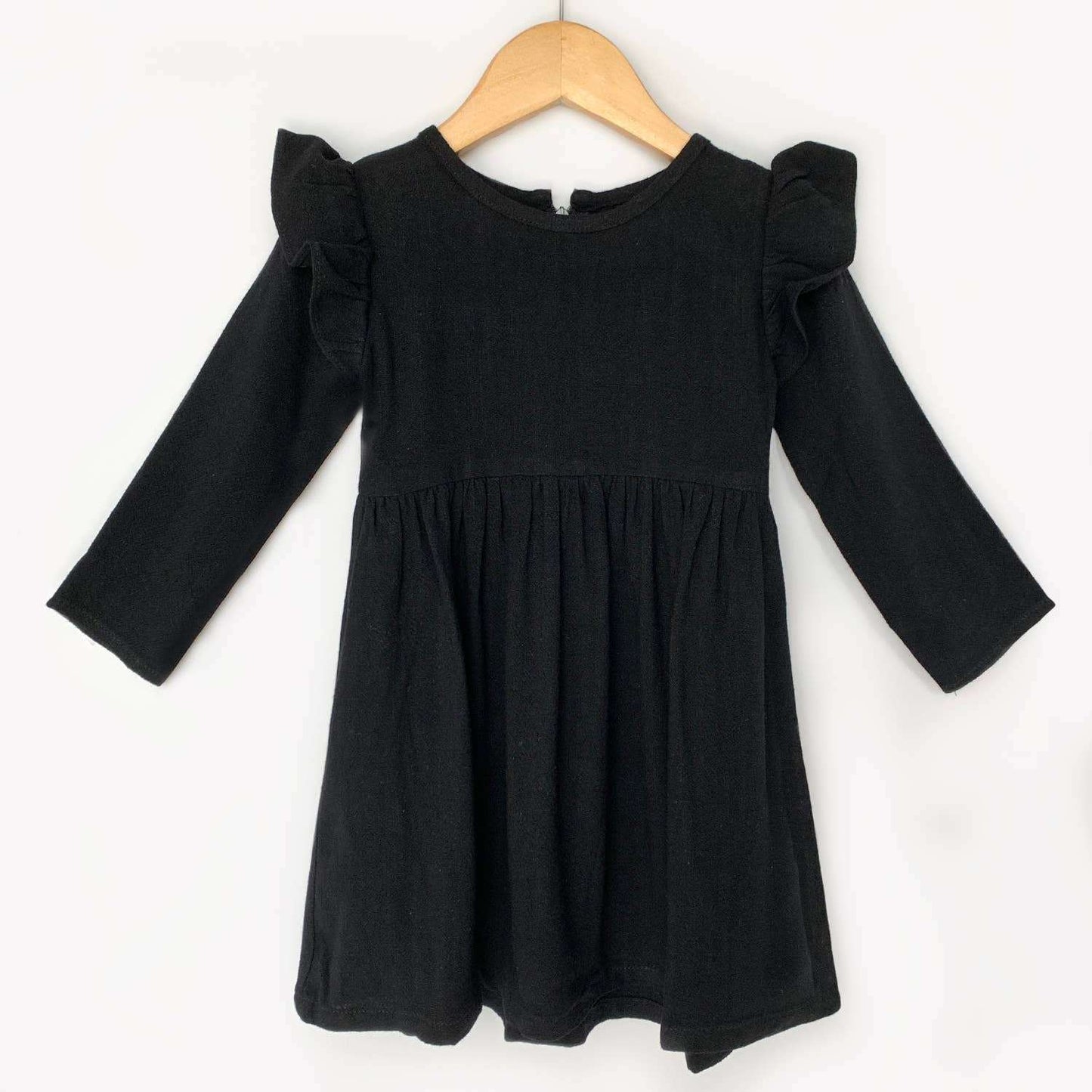 Black long sleeve linen dress with flutter sleeves on hanger.