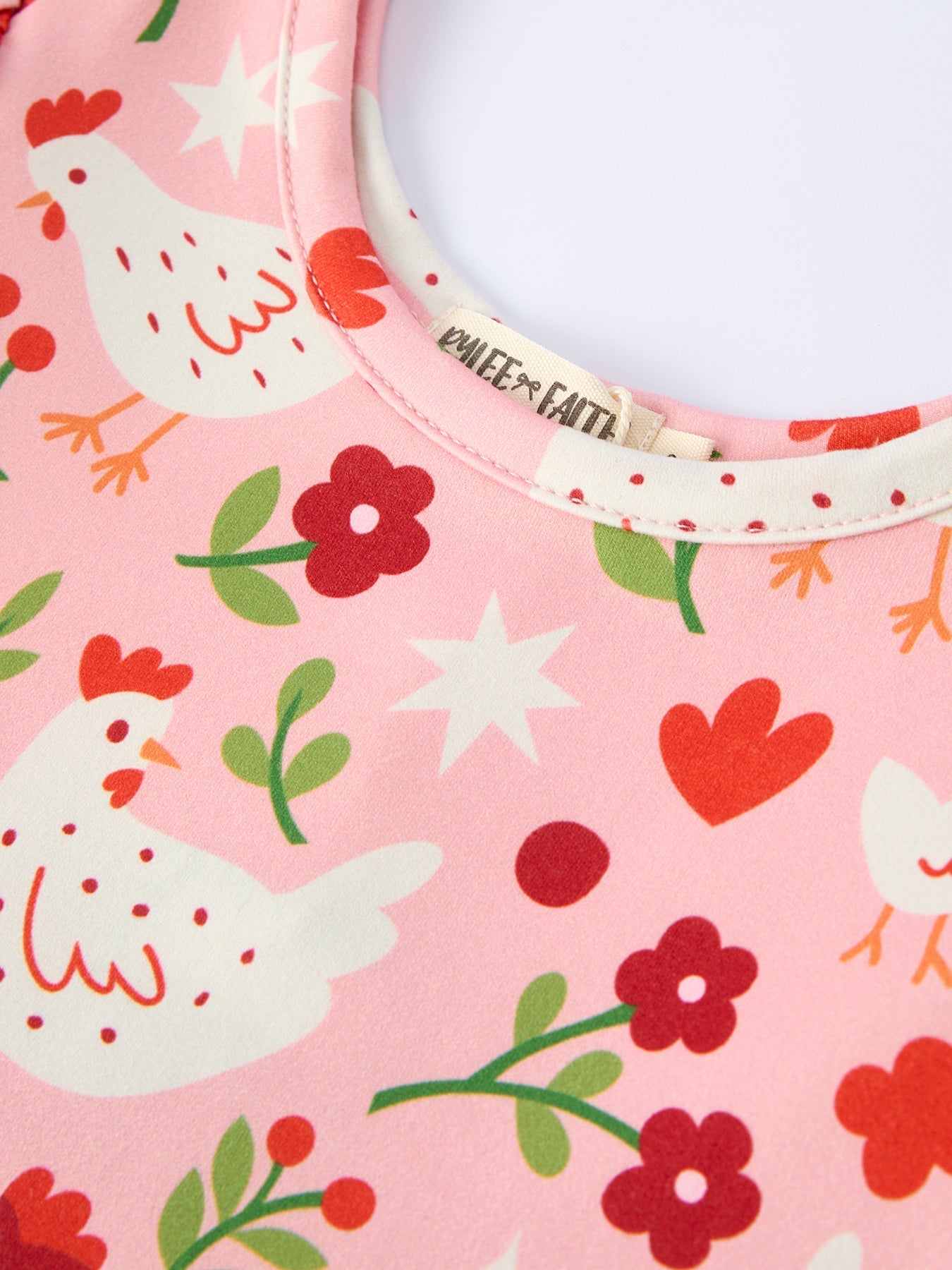 Children's bib with chicken and flower pattern on a pink background