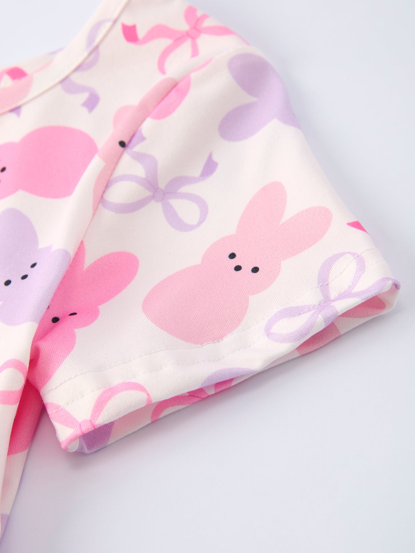 Fabric with pink bunny and bow pattern on a white background