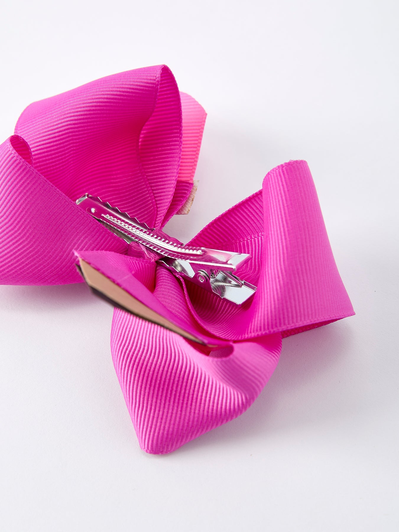 Pencil bow hair clip clipped in girl's hair