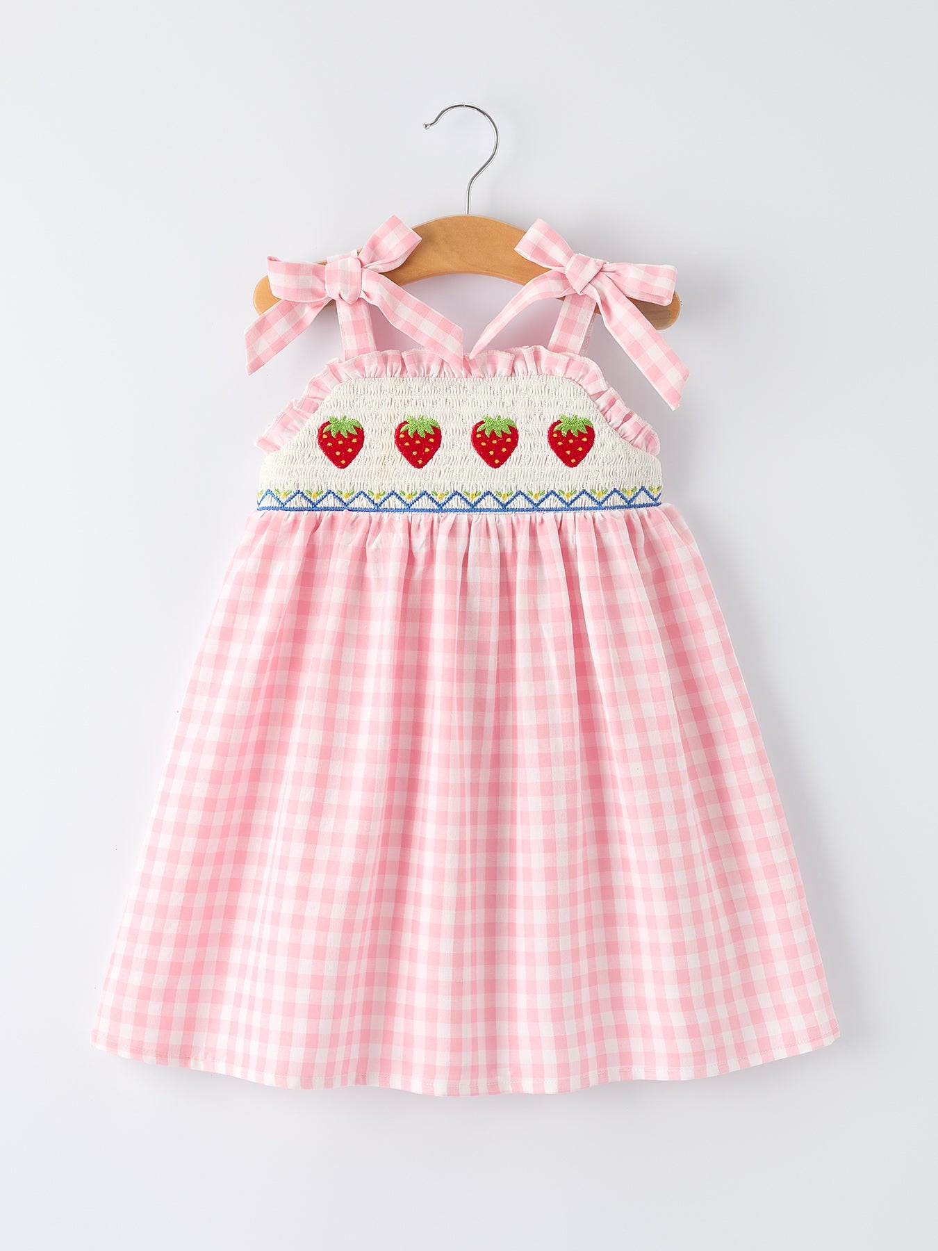 Pink checkered dress with strawberry design on a hanger against a white background