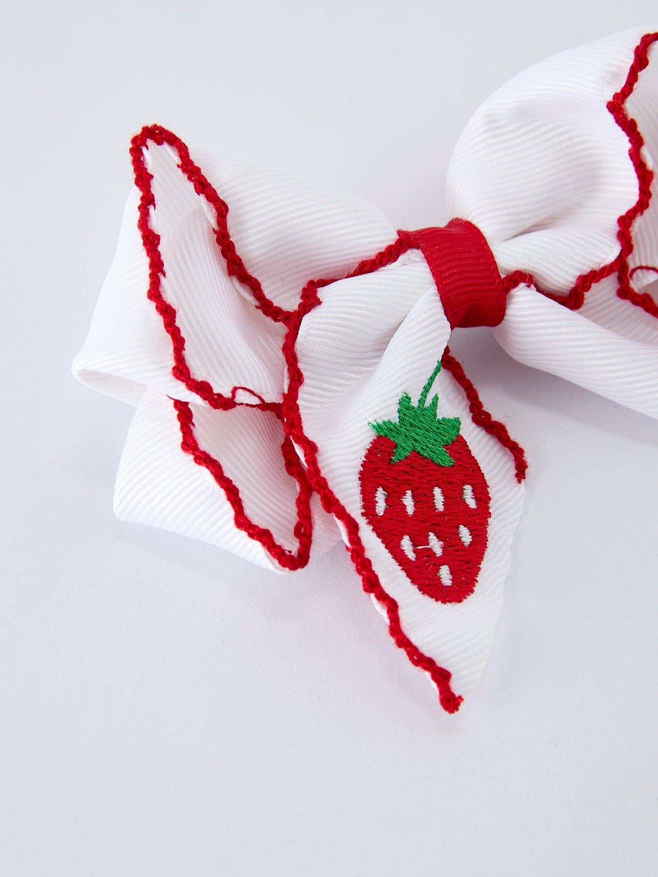White hair bow with strawberry embroidery, close-up detail