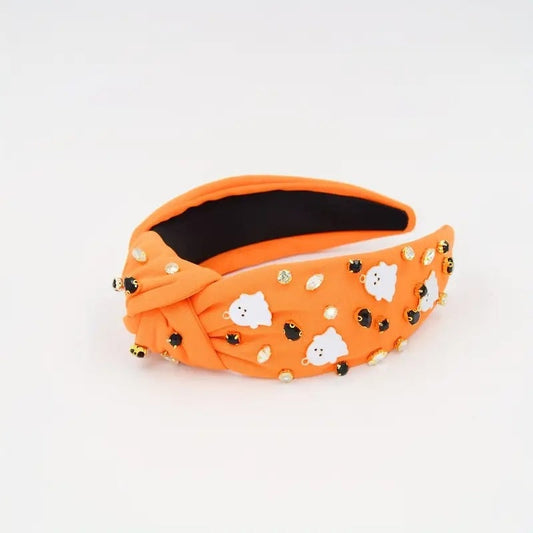 Orange spooky knotted headband with ghost designs and decorative beads for Halloween.