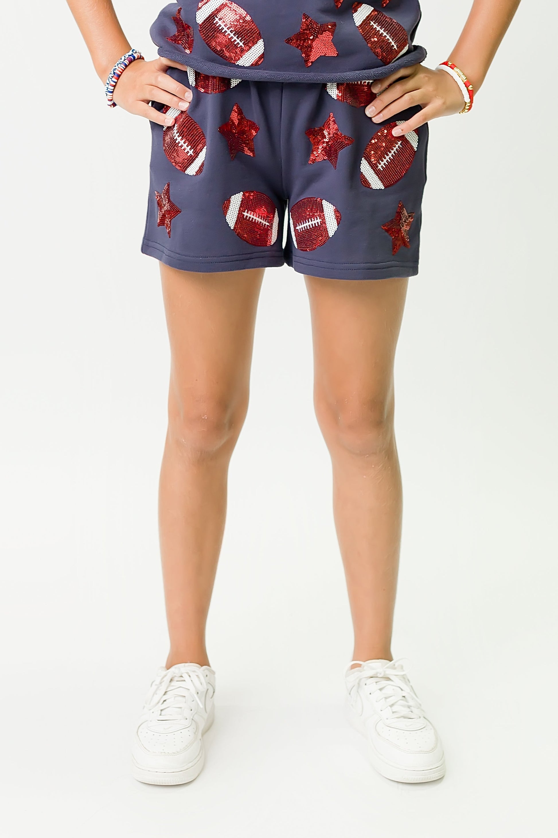 Navy and red football shorts with football and star designs worn by a child