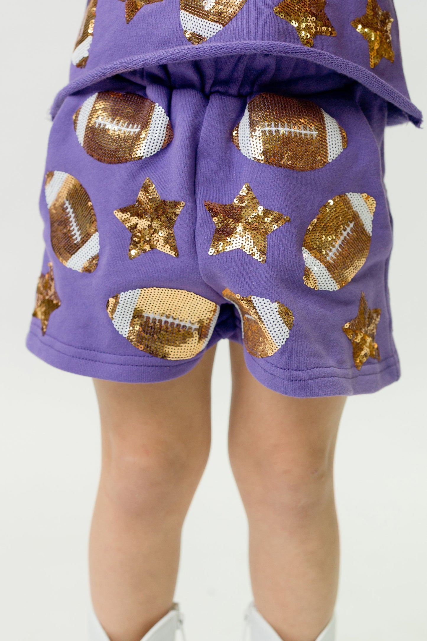 Purple football shorts with sequin football and star designs, lightweight and comfortable for active wear