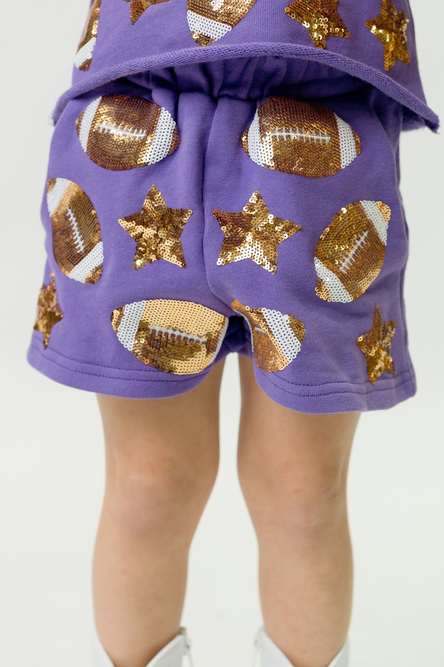 Purple football shorts with sequin football and star designs, lightweight and comfortable for active wear