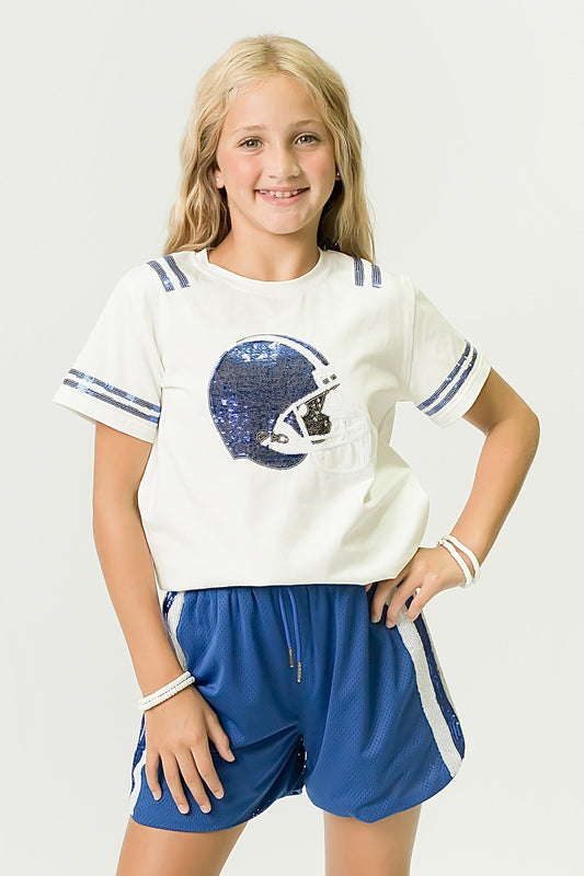 Girl wearing royal blue and white helmet shirt with matching blue shorts smiling.
