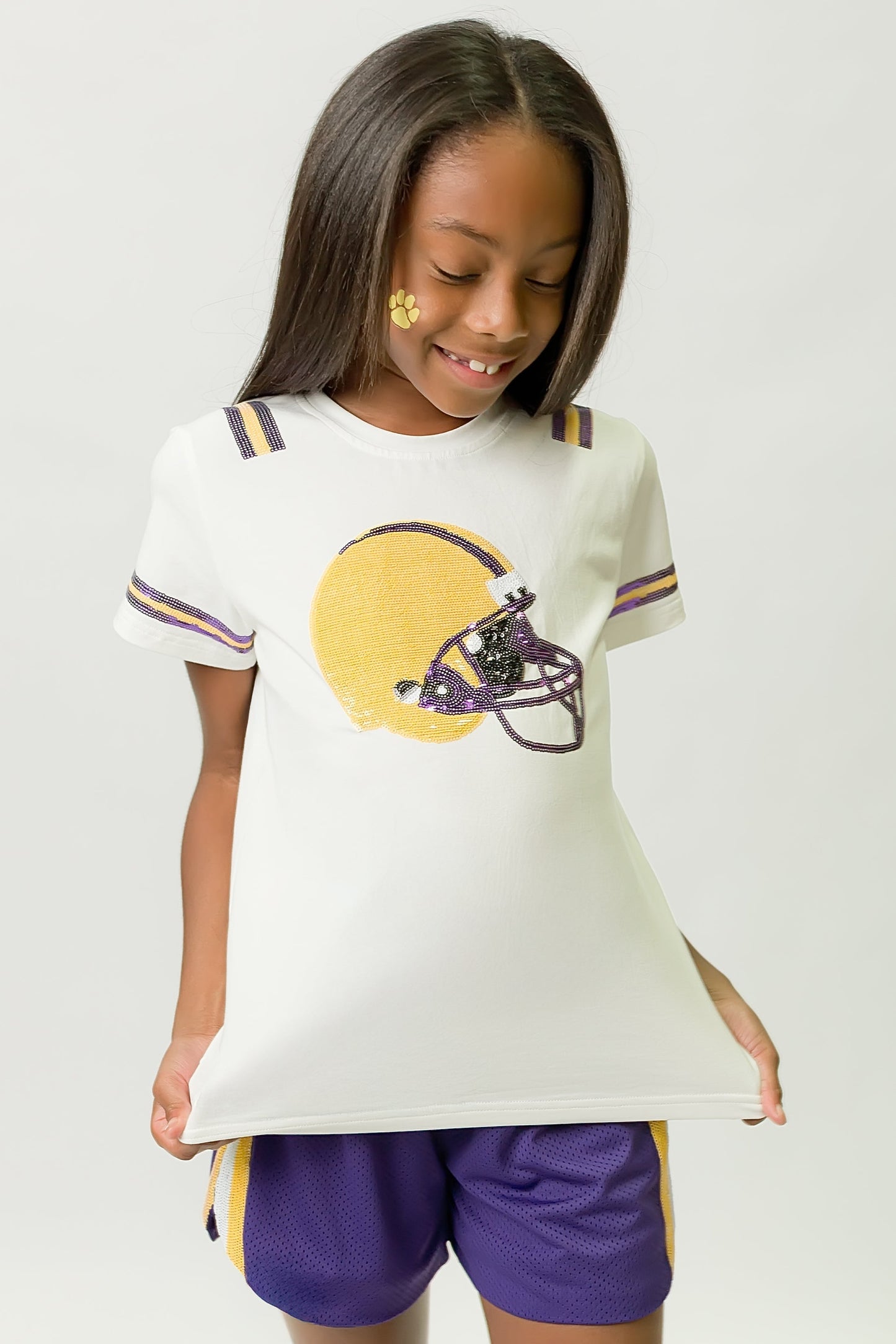 Girl wearing a Purple and Yellow Helmet Shirt with matching shorts and playful face paint