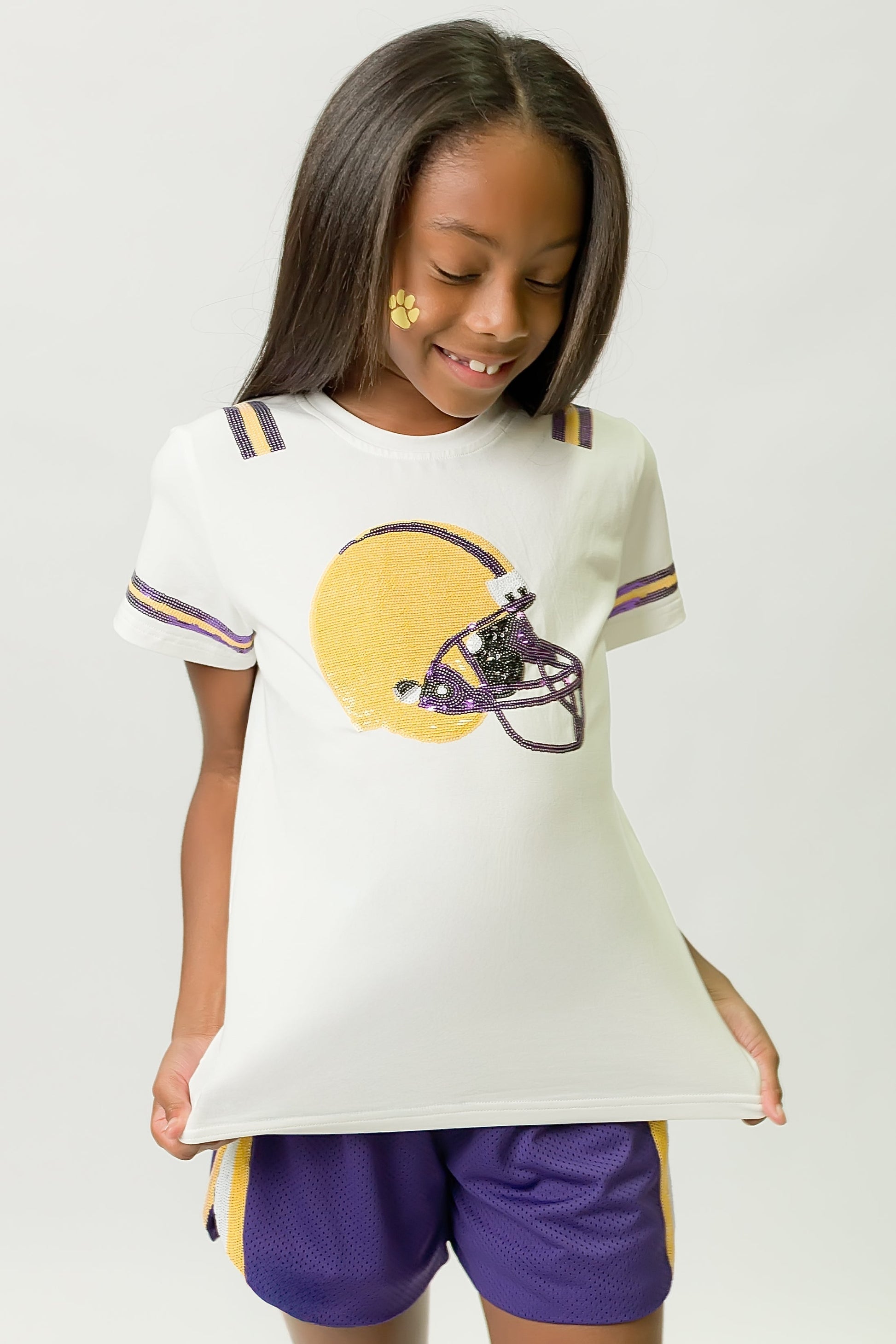 Girl wearing a Purple and Yellow Helmet Shirt with matching shorts and playful face paint