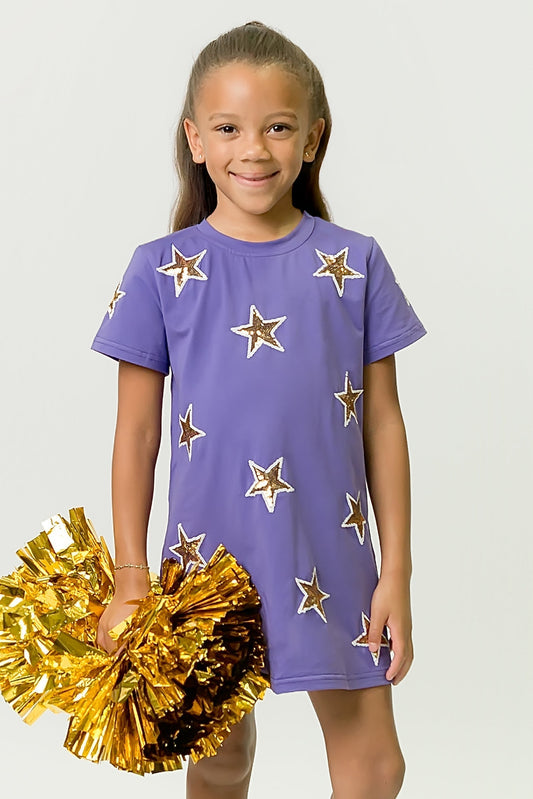 Girl wearing purple and gold star dress holding gold pom-poms