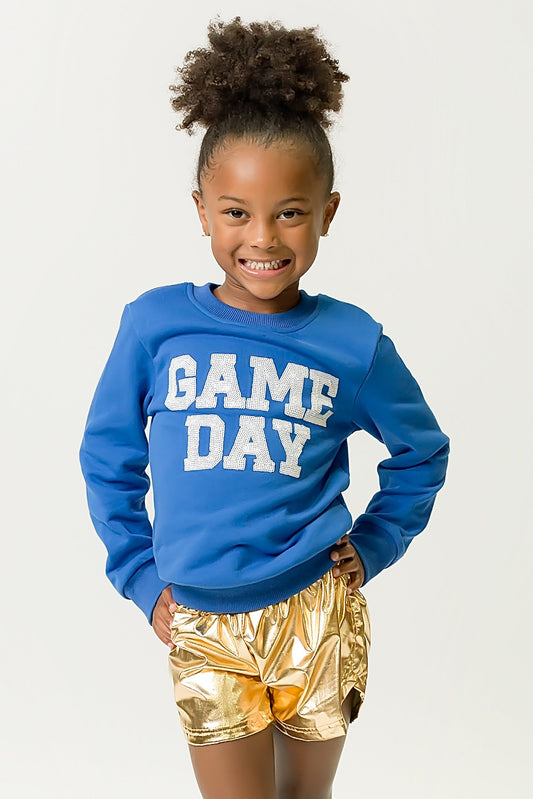 Girl wearing royal blue gameday sweatshirt with "GAME DAY" text and gold shorts