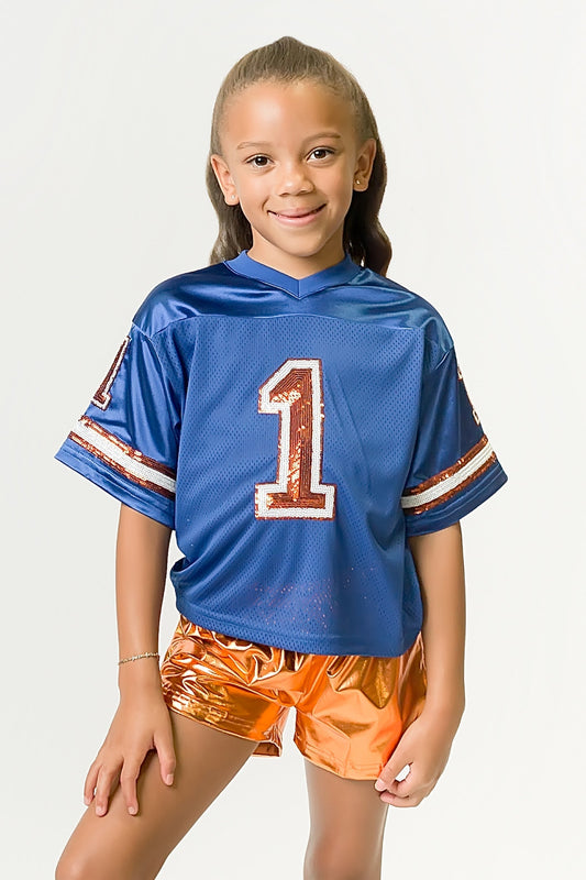Child wearing royal blue and orange sequin jersey with number one design