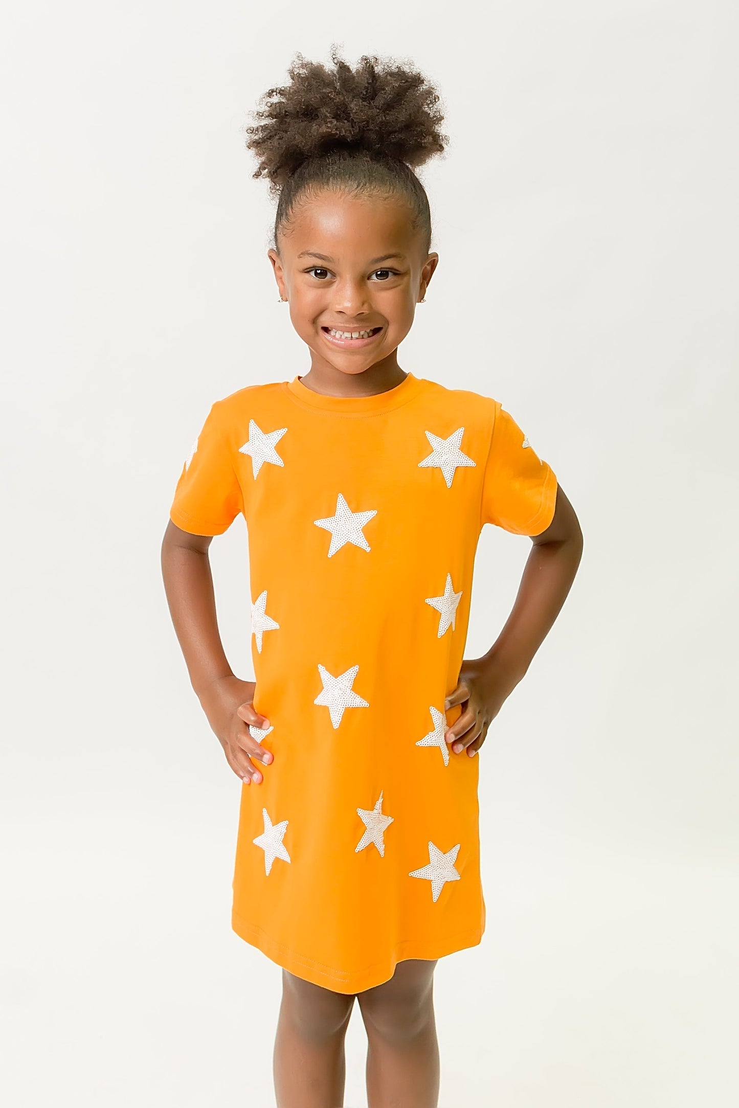 Girl wearing bright orange dress with white star pattern Orange Star Dress