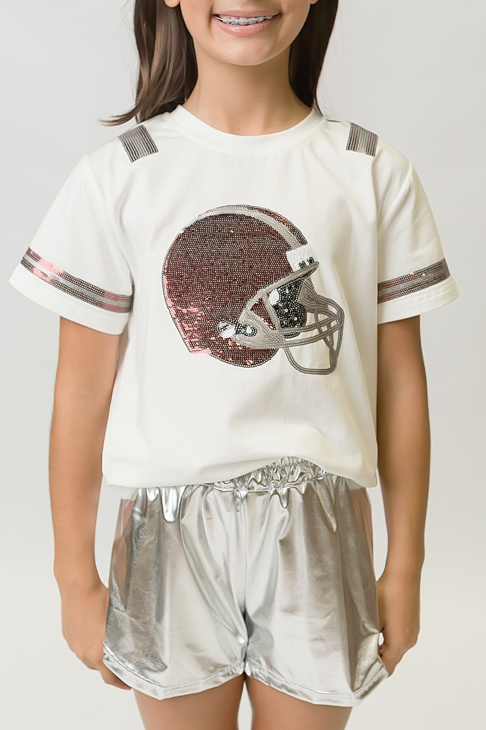Girl wearing white Maroon and Silver Helmet Shirt with shiny helmet graphic and silver shorts