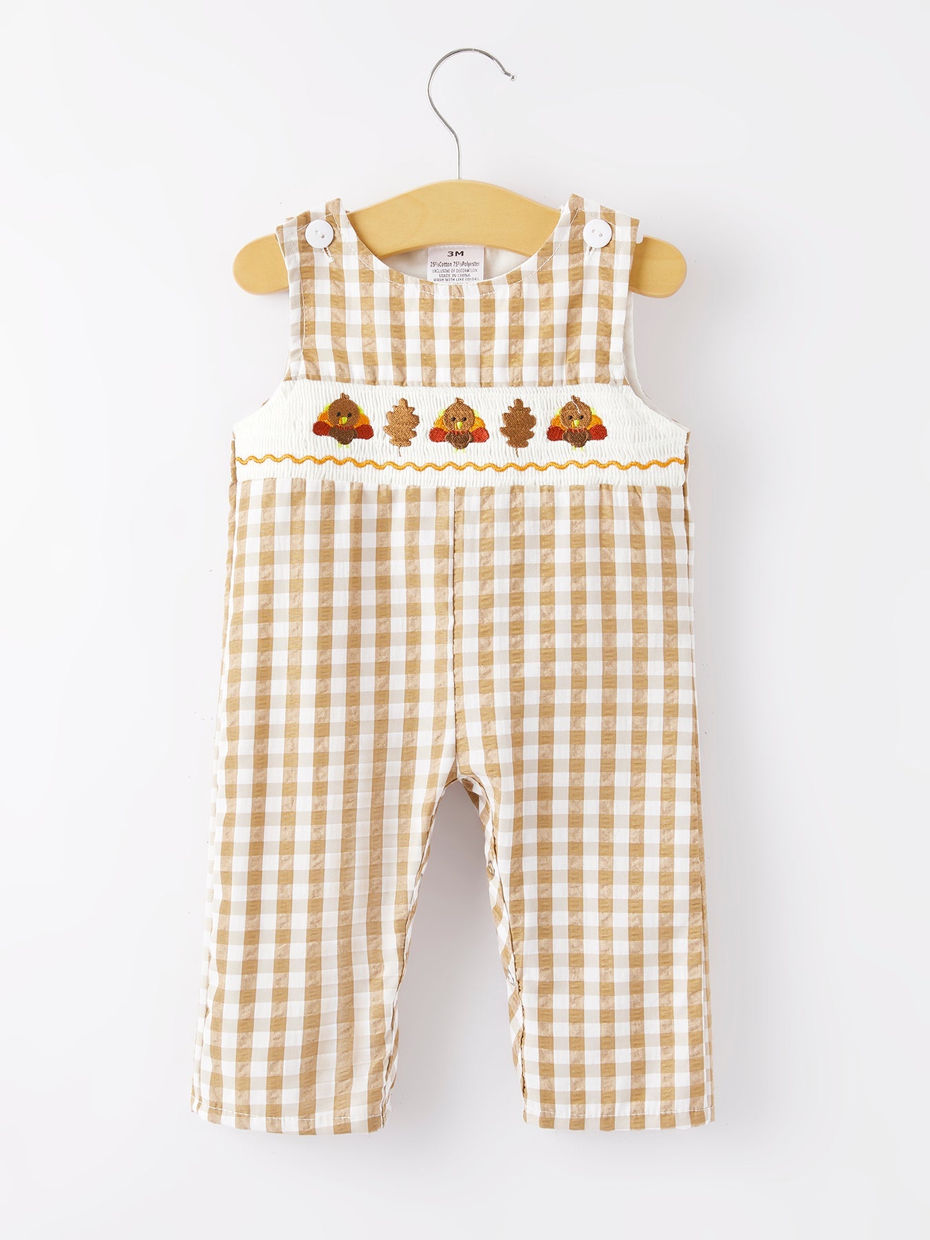 Checkered baby romper with embroidered designs on a white background