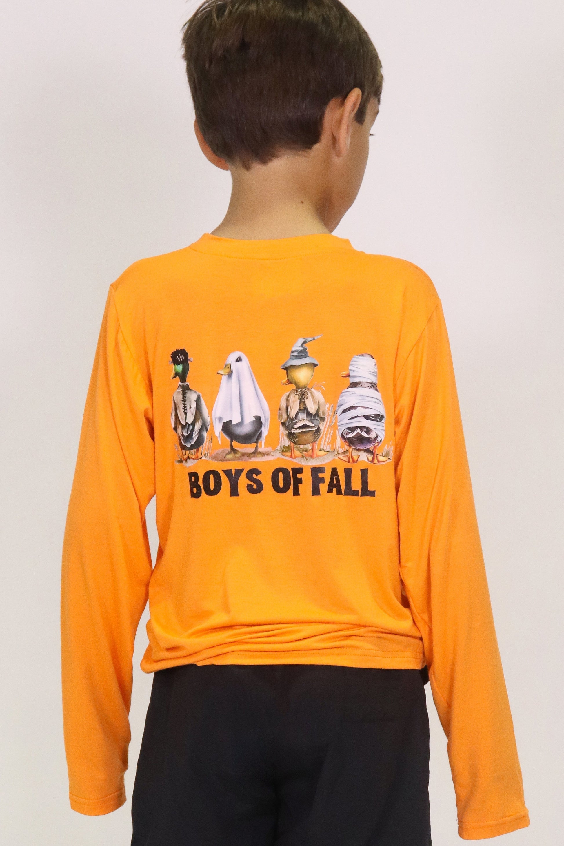Back view of boy wearing orange Boys of Fall Long Sleeve Shirt with fall-themed ghost characters and front pocket.