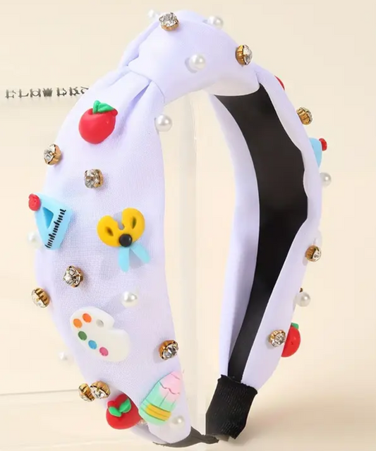 White back to school headband decorated with colorful strawberry, butterfly, paint palette, cupcake charms and jeweled accents