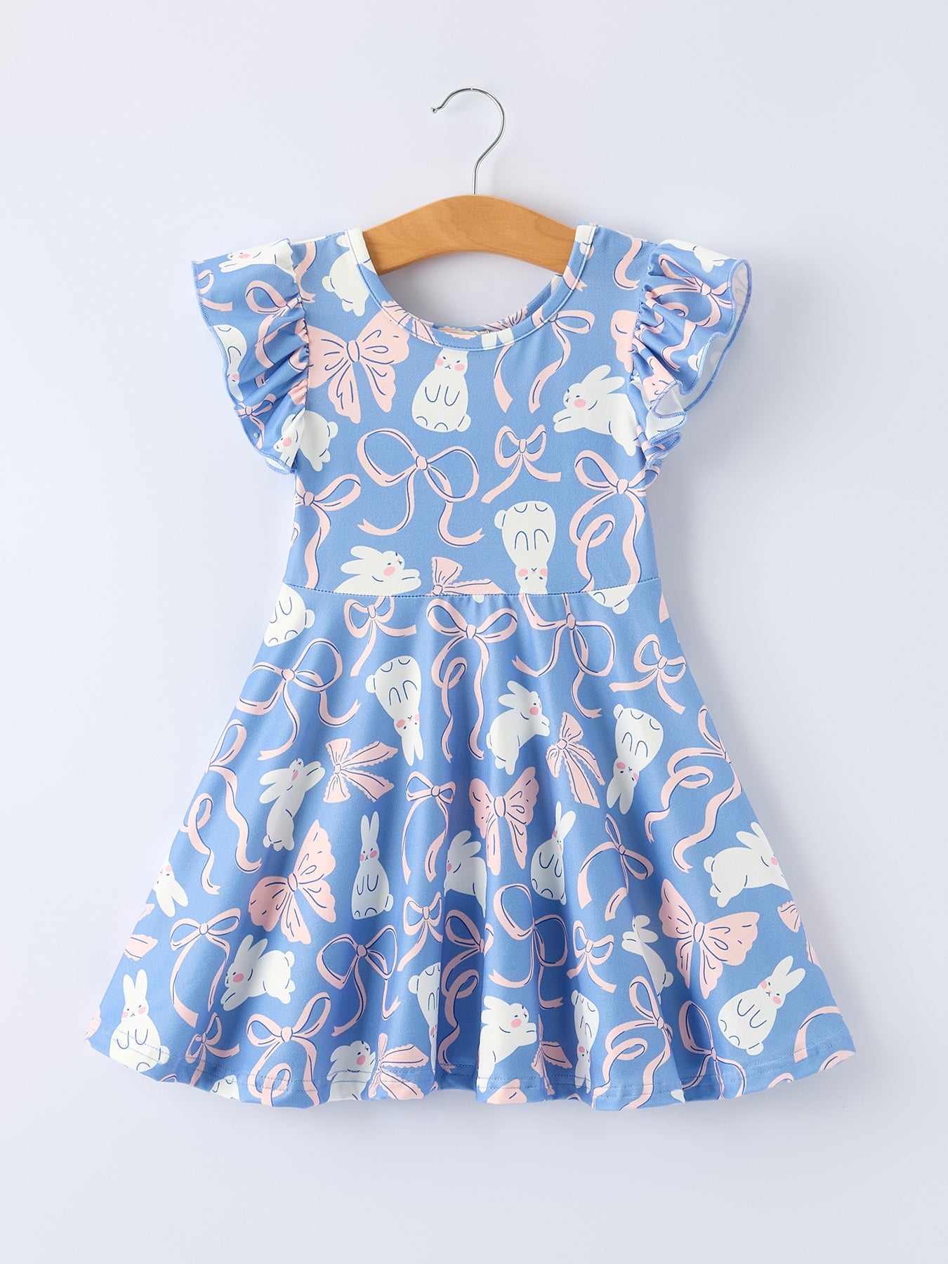 Blue dress with floral and bow pattern on a hanger against a white background
