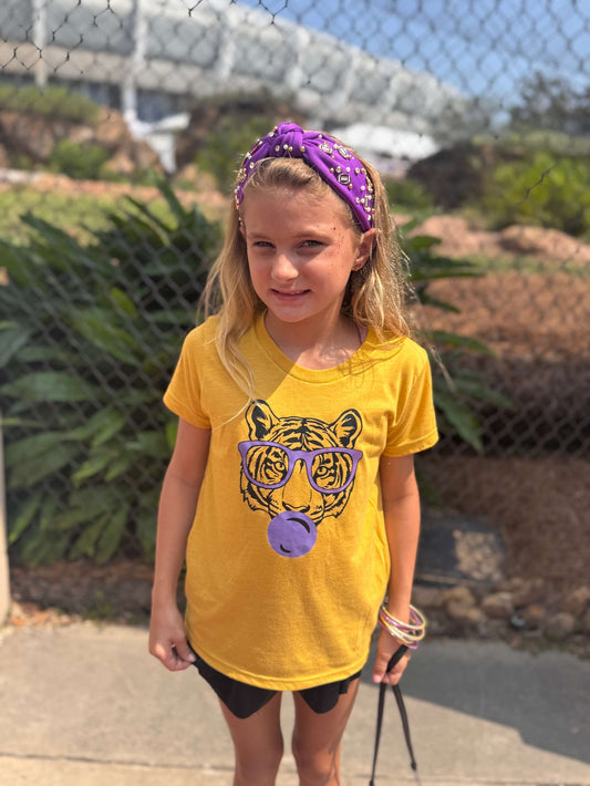 Young girl wearing purple sporty knotted headband with football design outdoors