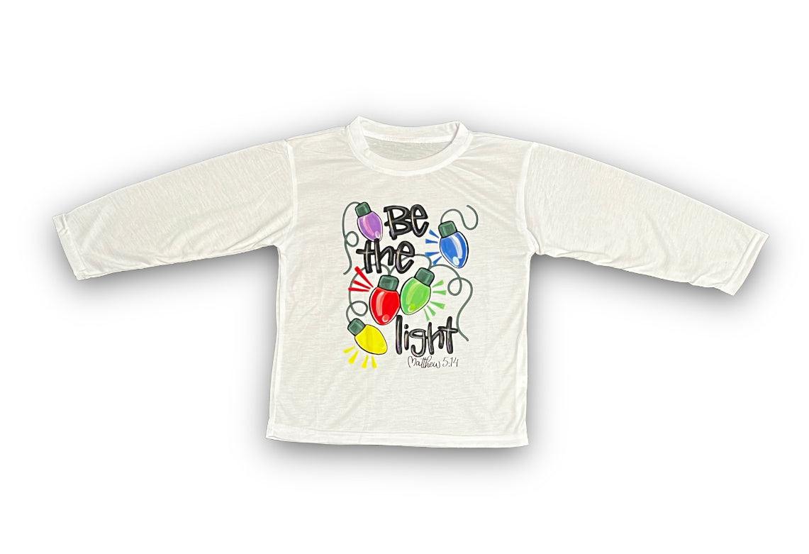 Kids white Be the Light Long Sleeve shirt with colorful string lights graphic and motivational text