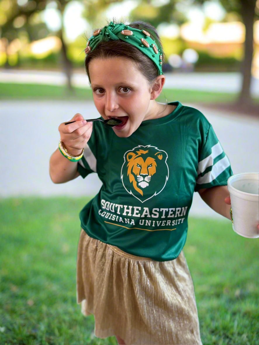 Person wearing a Southeastern Louisiana University shirt with a green background