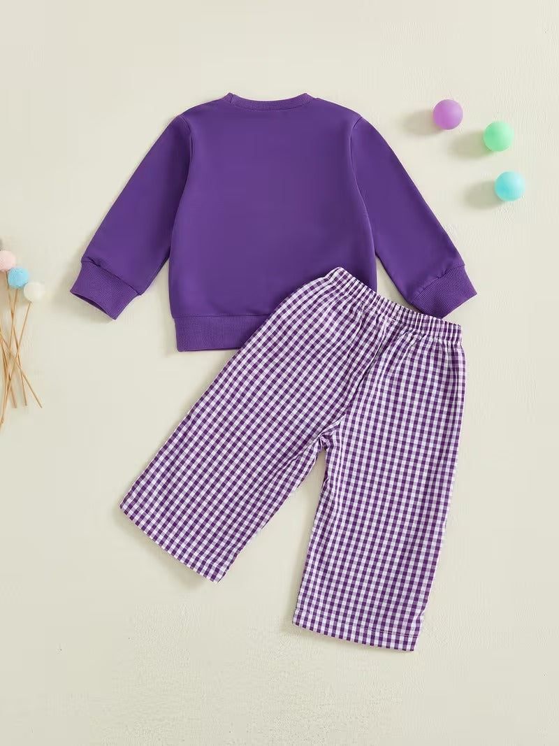 Purple sweatshirt and checkered pants set on a light beige background