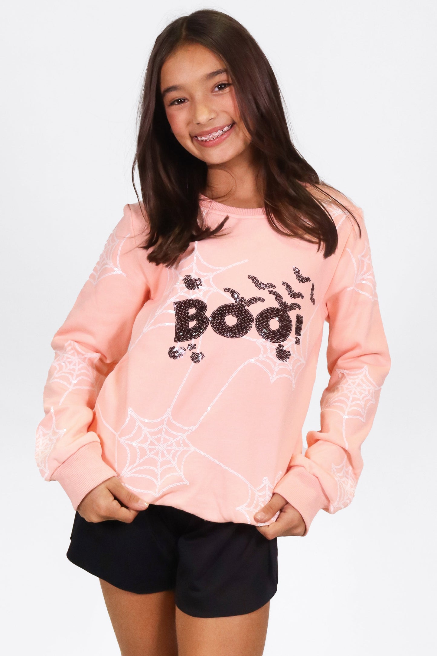 Girl wearing Pink Boo Spider Web Sweatshirt with spider web and "Boo!" design