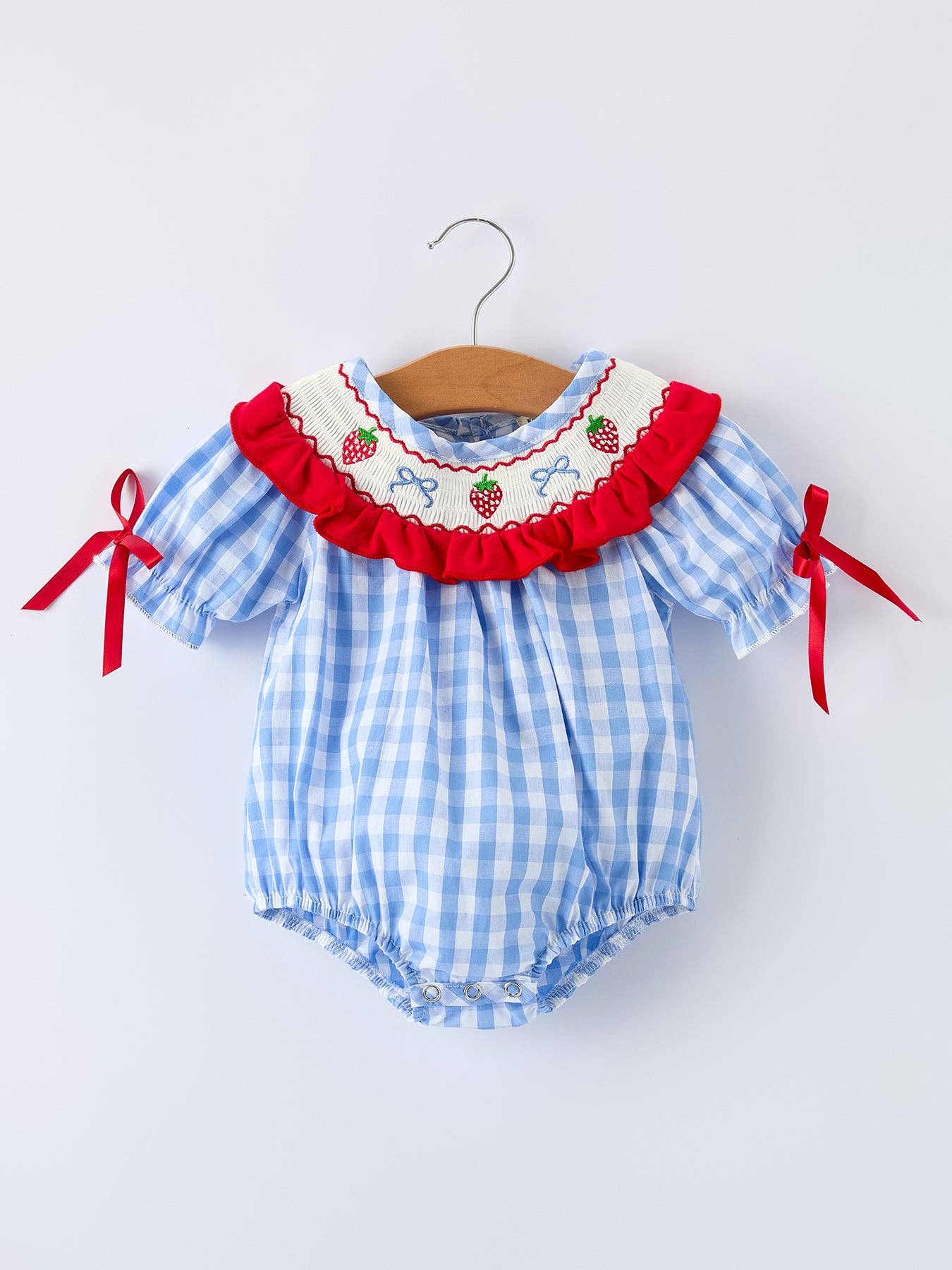 Baby romper with blue checkered pattern and red accents on a white background