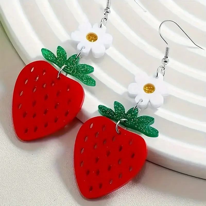 Strawberry-shaped dangle earrings with flower accents on a white background.