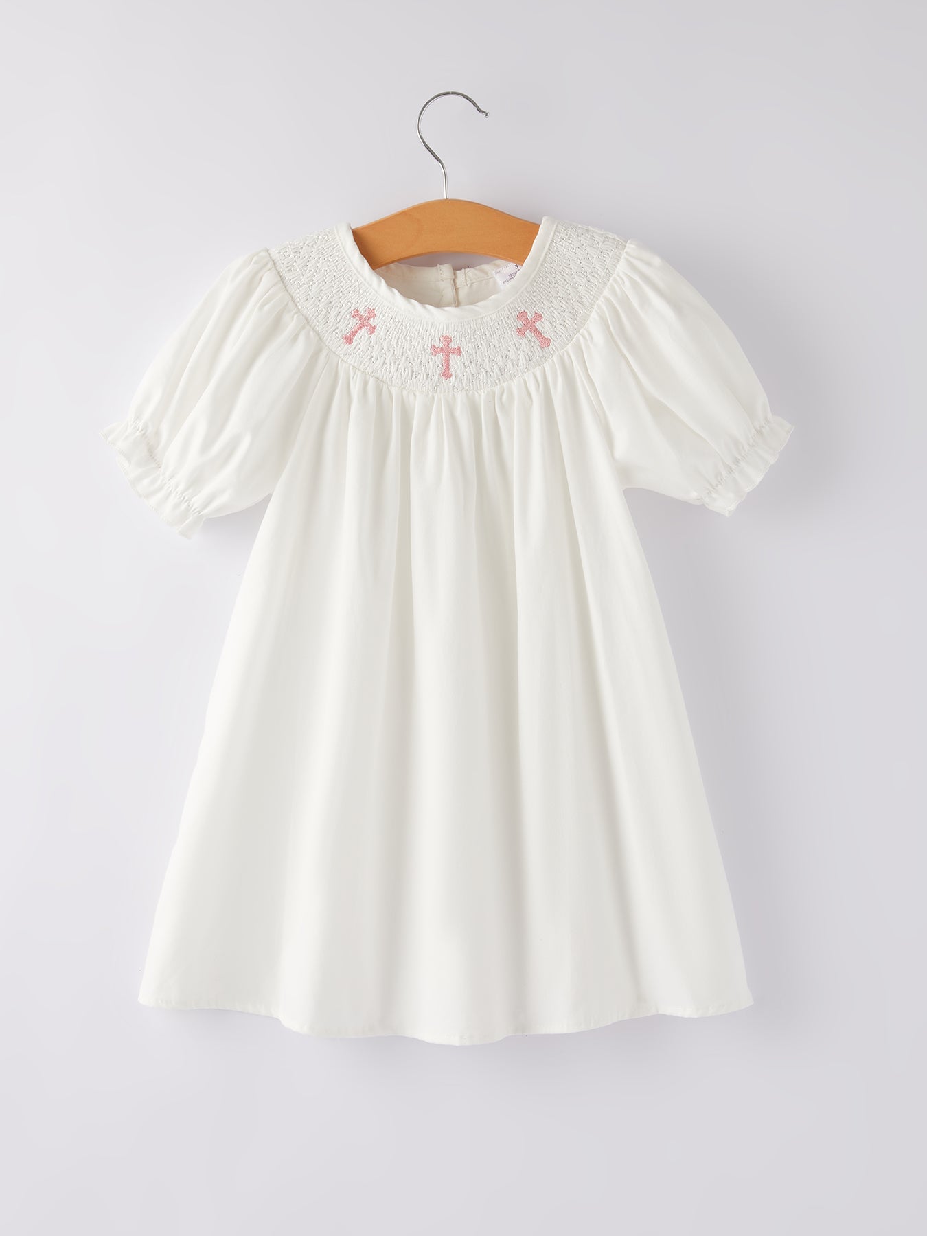 White hand-smocked christening dress for girls with pink cross embroidery and bishop sleeves in 100% cotton