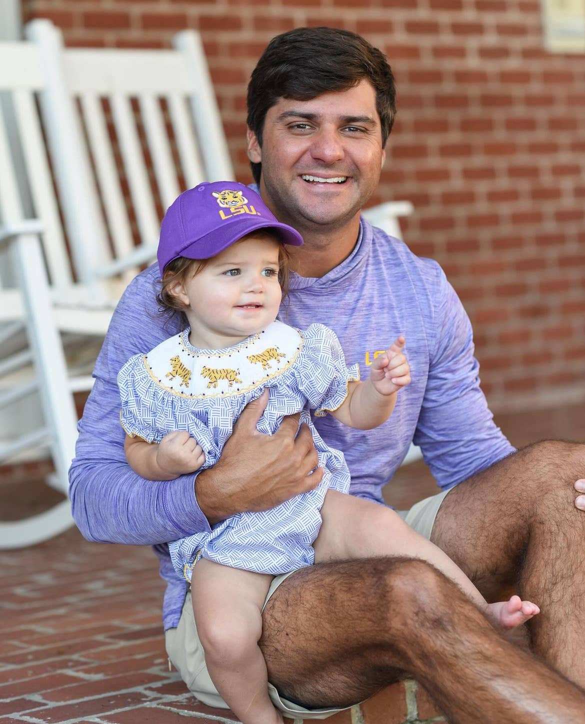 Little girl with dad wearing LSU Tigers ballcap