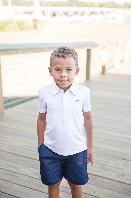 Saltwater Boys Company white offshore fishing polo worn by child on wooden deck.